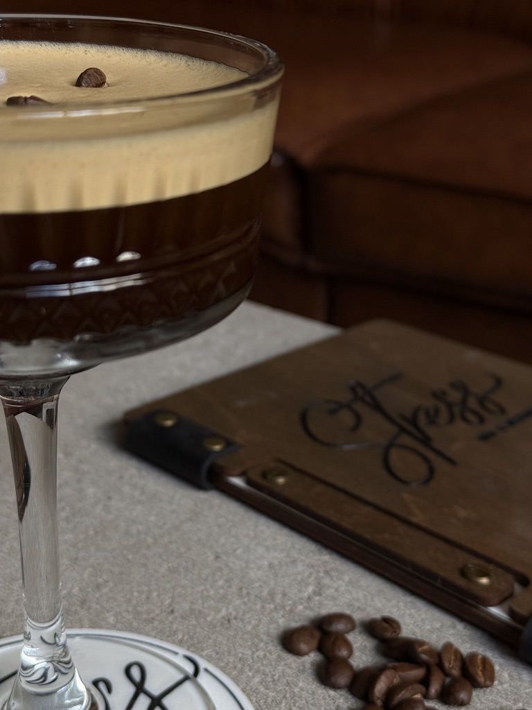Stresspresso Martini mit Kaffeebohnen neben der Stress-Getränkekarte aus Holz